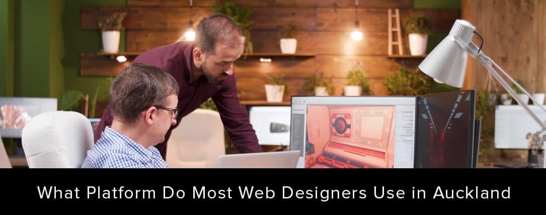 Web designers collaborating in an office setting, discussing popular web design platforms in Auckland, with a focus on digital design displayed on computer screens.